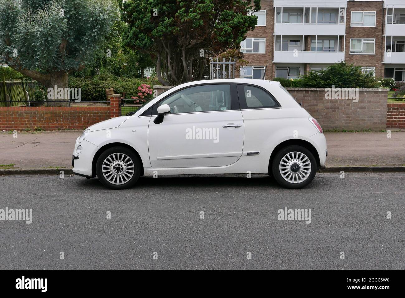 30 August 2021 - Essex, UK: White Fiat 500 parked in road in front of apartments Stock Photo