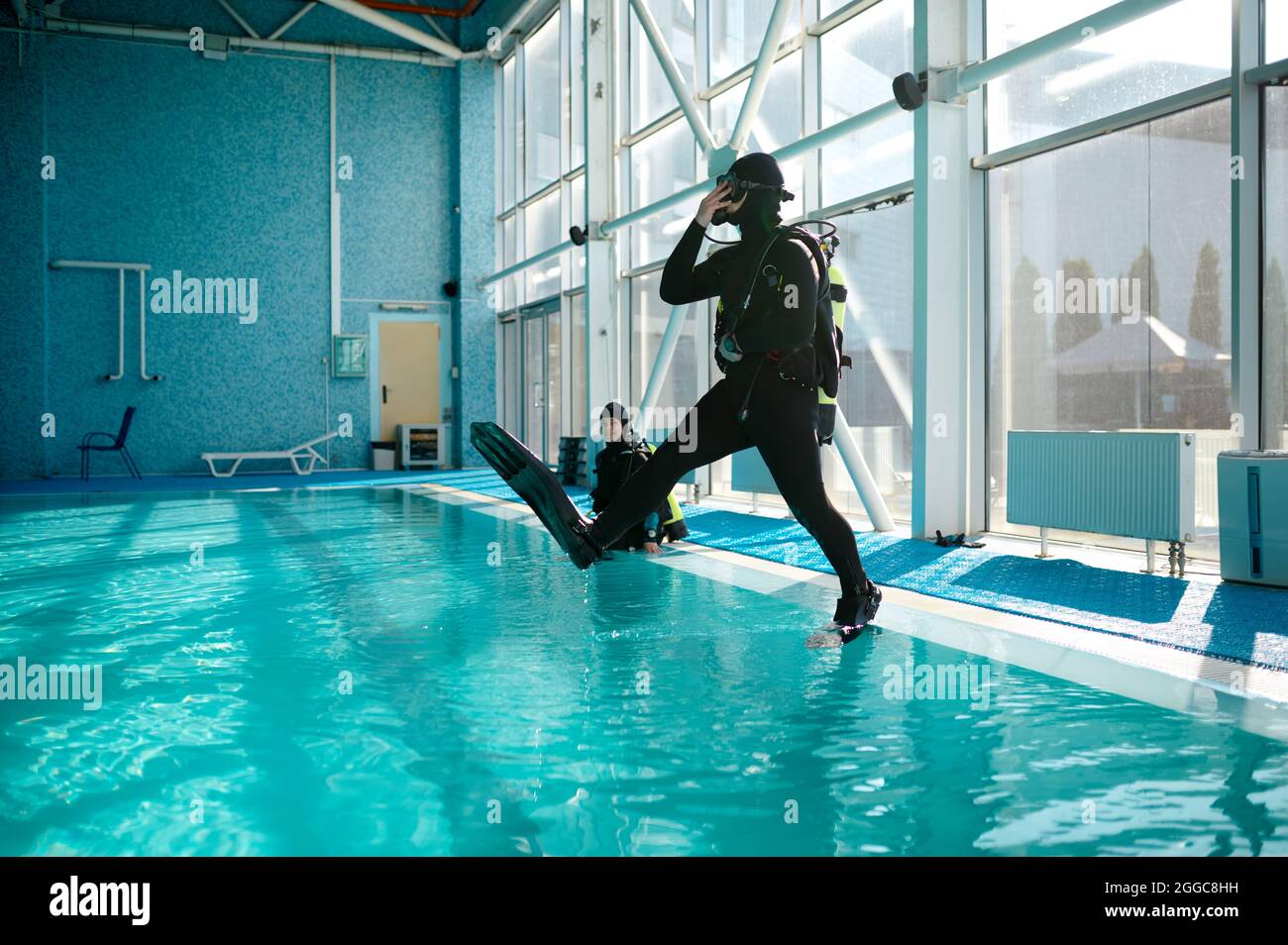Diver in scuba gear jumps into the pool, diving Stock Photo Alamy