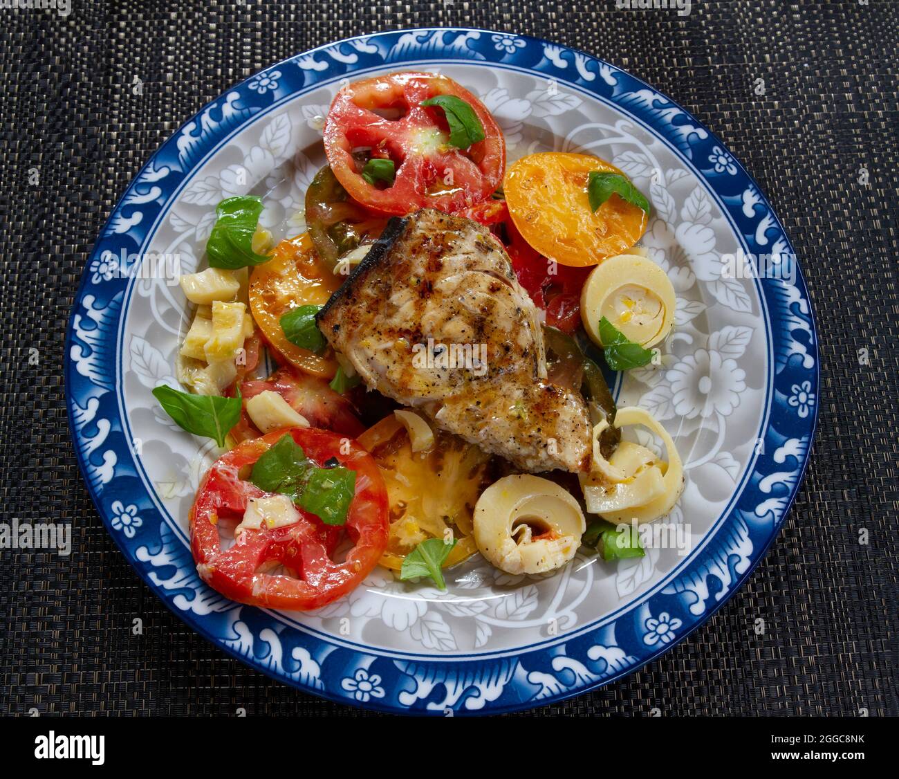 Grilled Swordfish with Heirloom Tomato's and Hearts of Palm Salad. Stock Photo