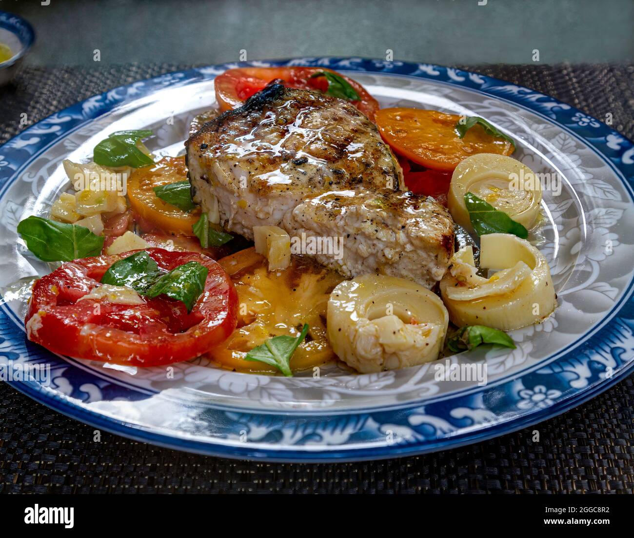 Grilled Swordfish with Heirloom Tomato's and Hearts of Palm Salad. Stock Photo