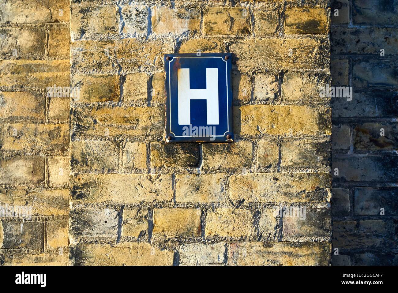 The letter H on a sign on a wall Stock Photo