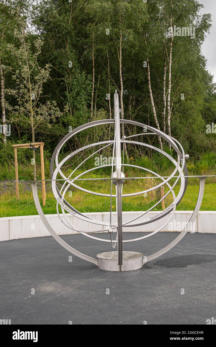 Transinne, Wallonia, Belgium - August 10, 2021: Euro Space Center. Portrait of Celestial Equator model or Armillary Sphere on green domain with tree f Stock Photo