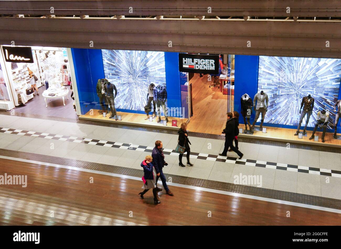 POZNAN, POLAND - Dec 14, 2014: The people passing a Hilfiger clothing store in the Stary Browar shopping mall, Poznan, Poland Stock Photo