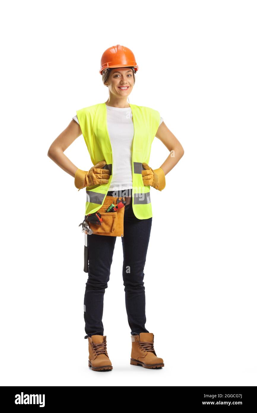 Full length portrait of a young female construction worker wearing a hardhat and a tool belt isolated on white background Stock Photo