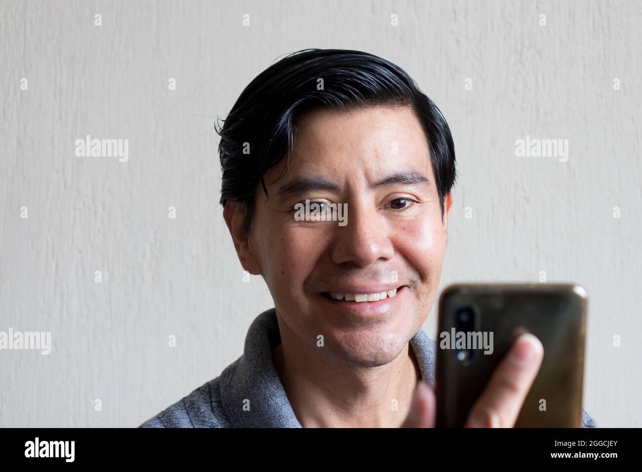 Hispanic man using his cellphone Stock Photo