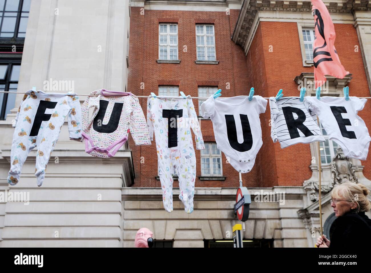 London, UK. Babygros on a washing line spelling 'future' at an Extinction Rebellion protest outside the Science Museum Stock Photo