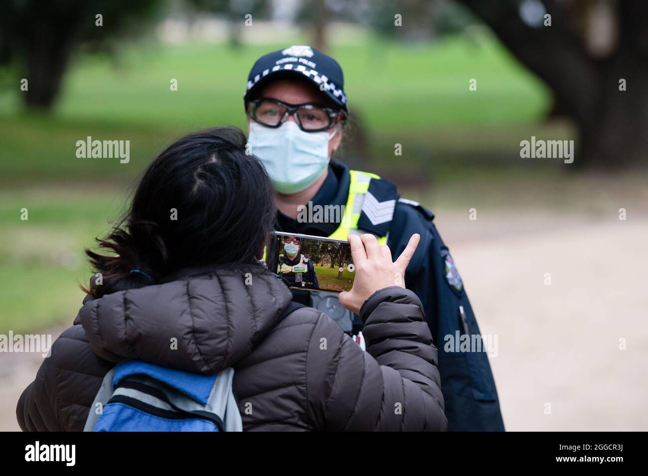 Melbourne, Australia, 31 August, 2021. A female protester films a police officer as she is questioned during a protest organised by Karen Brewer a New Zealand proprotor of Freemason conspiracy theory's, most demonstrators were detained and fined before a protest could take place. Credit: Michael Currie/Speed Media/Alamy Live News Stock Photo