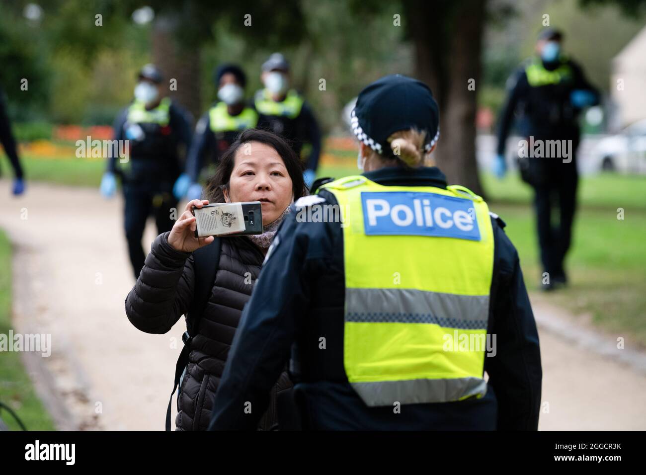 Melbourne, Australia, 31 August, 2021. A female protester films a police officer as she is questioned during a protest organised by Karen Brewer a New Zealand proprotor of Freemason conspiracy theory's, most demonstrators were detained and fined before a protest could take place. Credit: Michael Currie/Speed Media/Alamy Live News Stock Photo