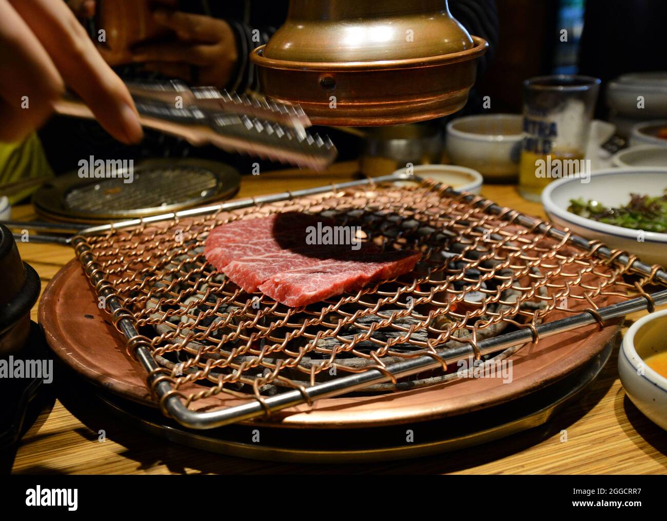 Grilling Korean beef in a traditional BBQ restaurant in Seoul, South