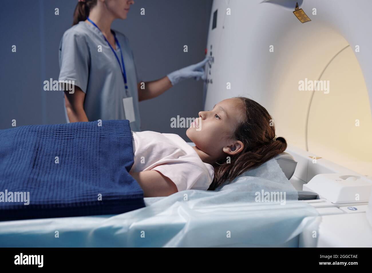 Adorable little girl undergoing computer tomography examination in scanning machine Stock Photo