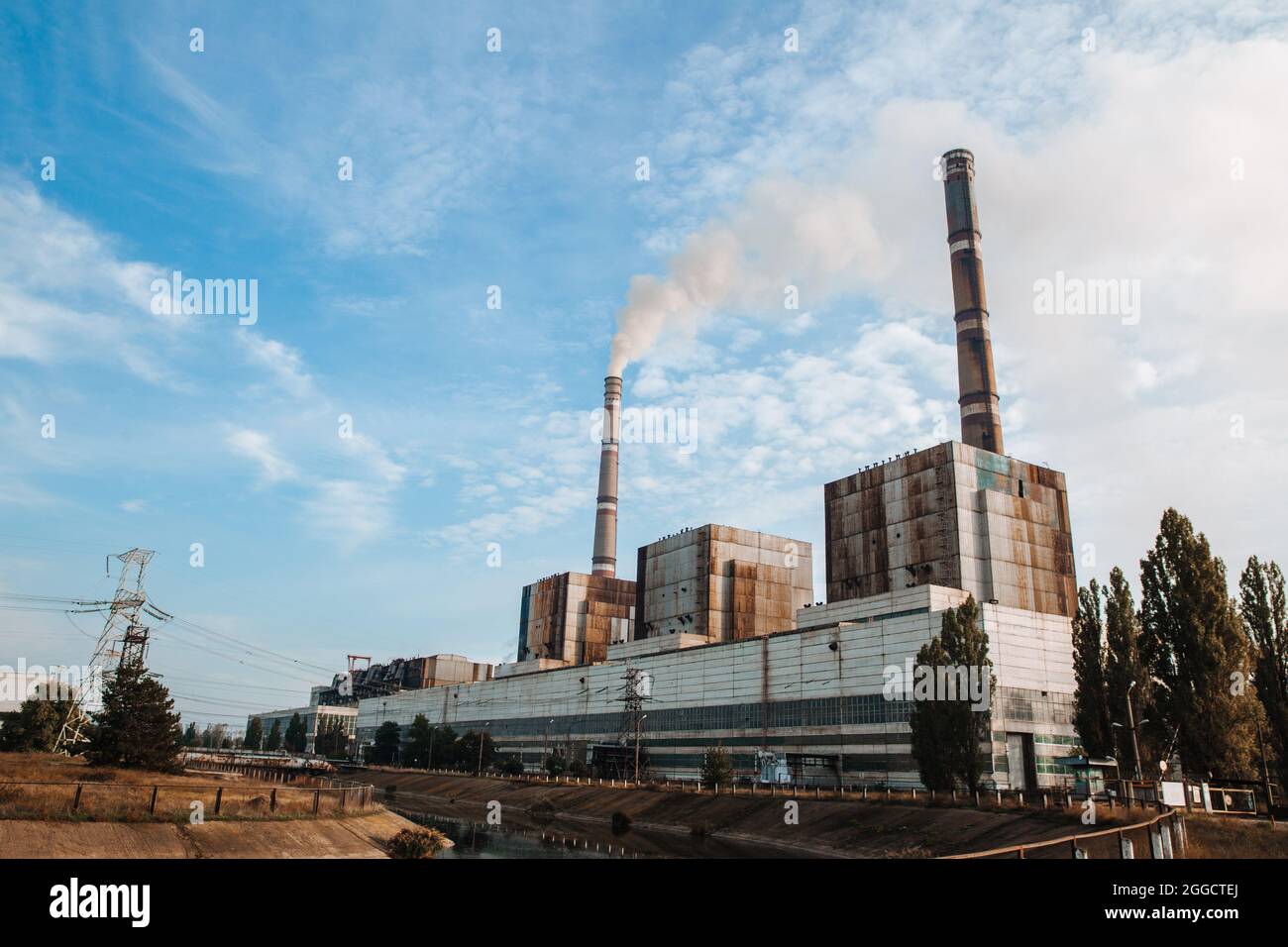 Air pollution, factory pipes, smoke from chimneys on sky background. Concept of industry, ecology, steam plant, heating season, global warming. Stock Photo