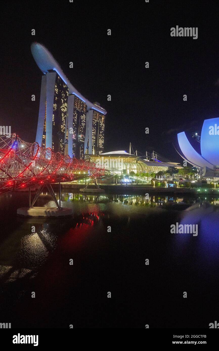 The skyline of Singapore at night with bright lights and reflections in the water Stock Photo