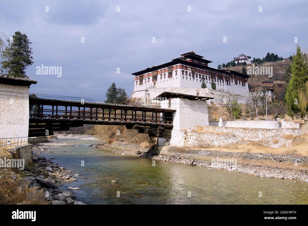 Rinpung Dzong (Buddhist fortified monastery) and the Nemi Zam cantilever bridge over the Pa Chhu (River), Paro, Bhutan- late afternoon Feb 2017 Stock Photo