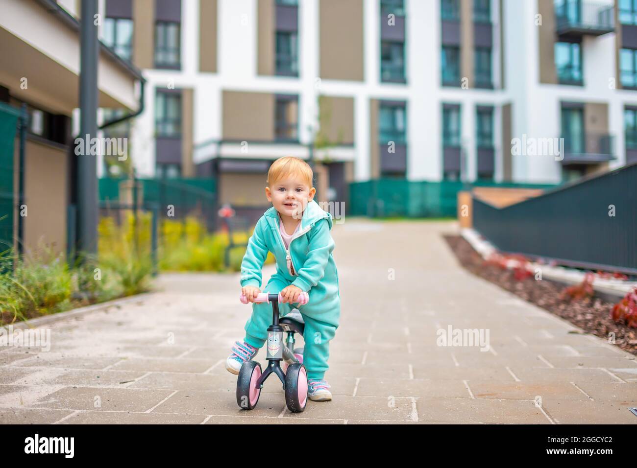 Little girl on baby bicycle hi res stock photography and images
