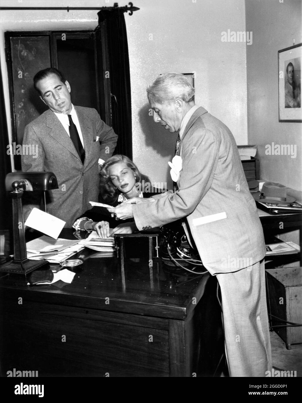 HUMPHREY BOGART and LAUREN BACALL with SID GRAUMAN in his office prior ...