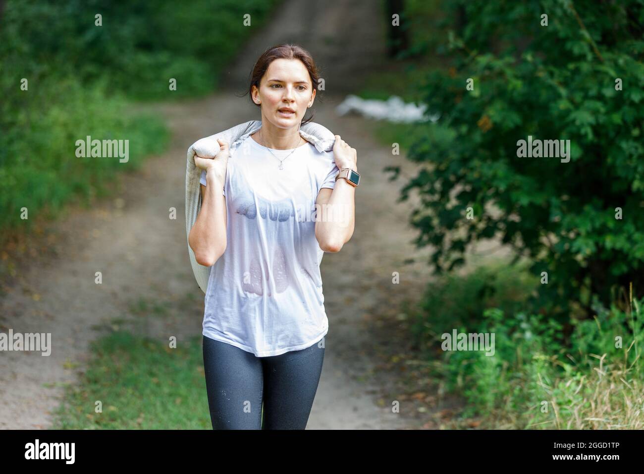 Young woman carying sand bag on her obstacle race course Stock Photo