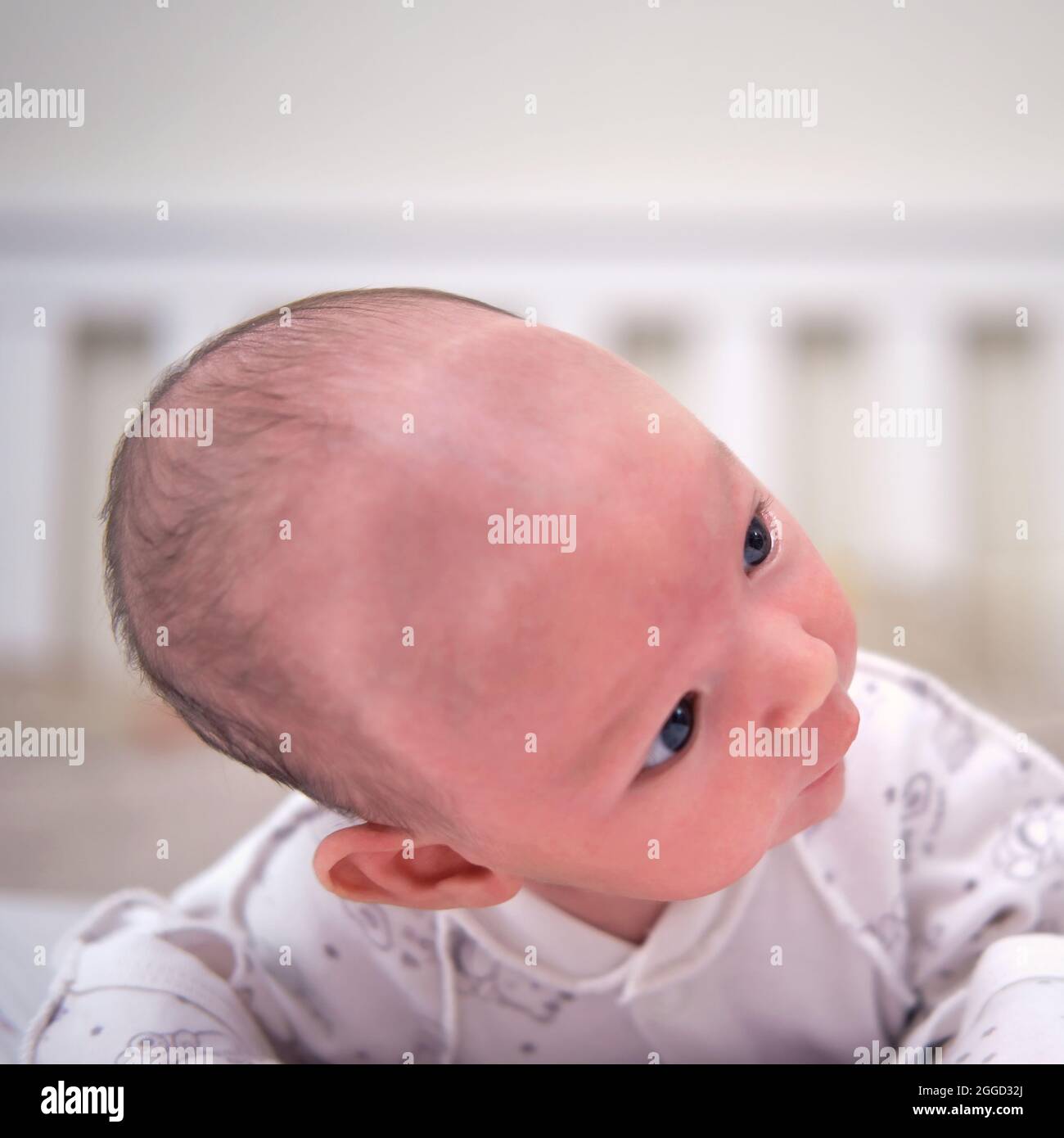A Baby Aged 1 Month Learns To Keep His Head Lying On His Stomach Caucasian Boy Child In A Home White Bedroom Stock Photo Alamy
