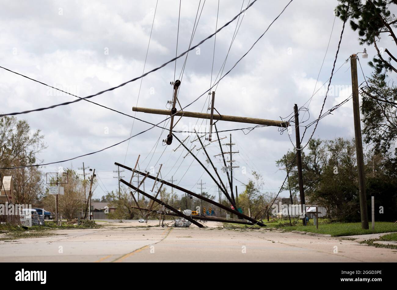 Houma, USA. 30th Aug, 2021. Power line poles are seen downed by