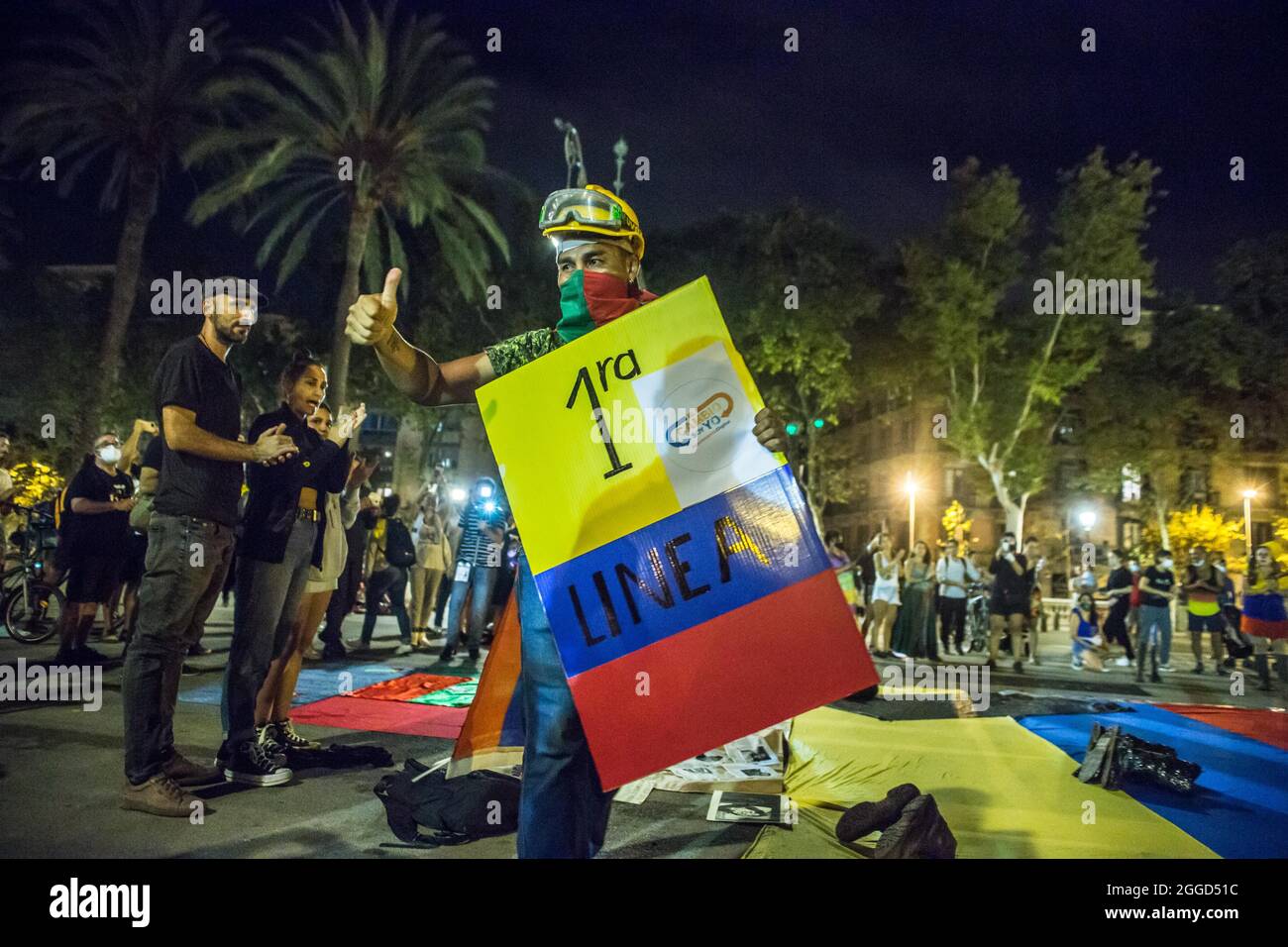 Barcelona, Spain. 30th Aug 2021. First line of defense in the anti-government protests in Colombia, Ricardo 'Profe' is seen with a banner with the colors of Colombia that says, first line the change is me. Around 200 people have demonstrated in front of the Arc de Triomf in Barcelona against the 6402 extrajudicial killings committed by the Army in the context of the Colombian armed conflict, a phenomenon known as 'false positives'. Credit: DAX Images/Alamy Live News Stock Photo