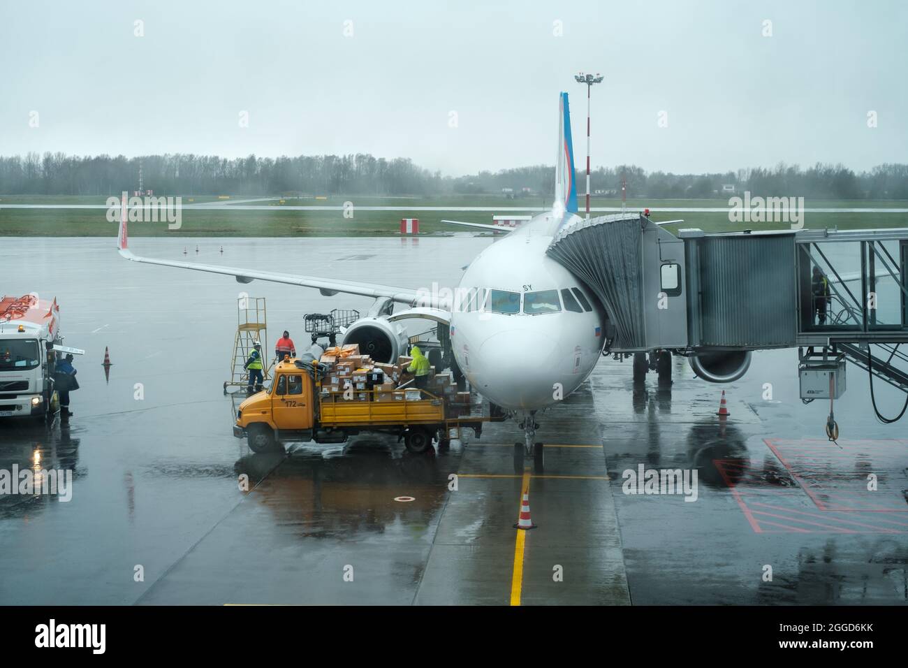 Workers uploading luggage in airplane Stock Photo