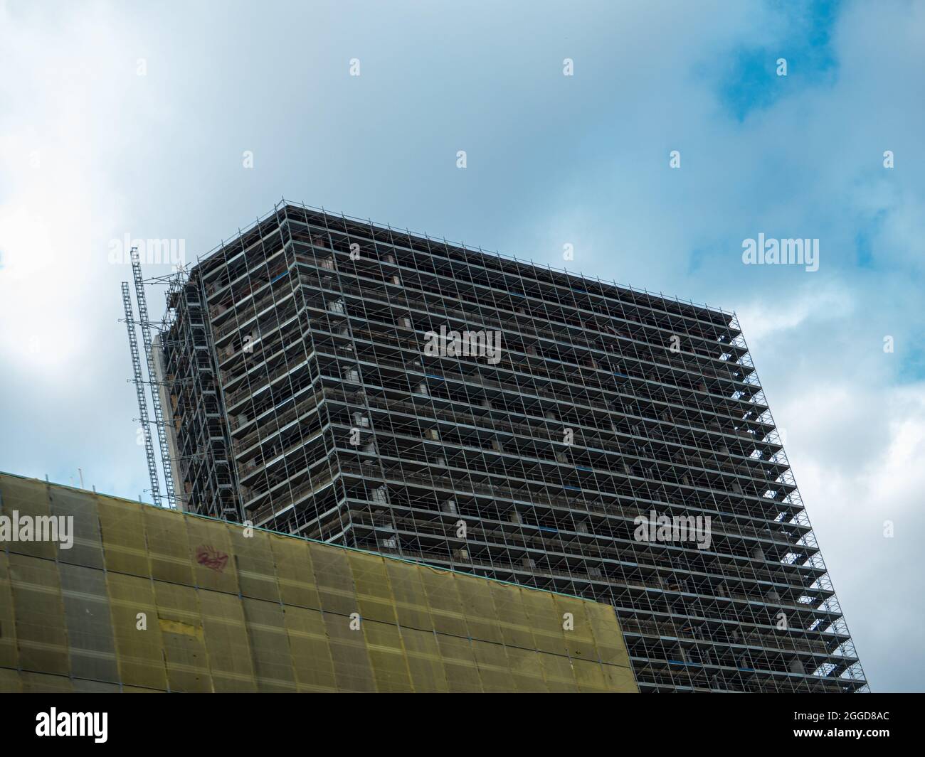 Low angle shot of a complex residential building against cloudy sky ...