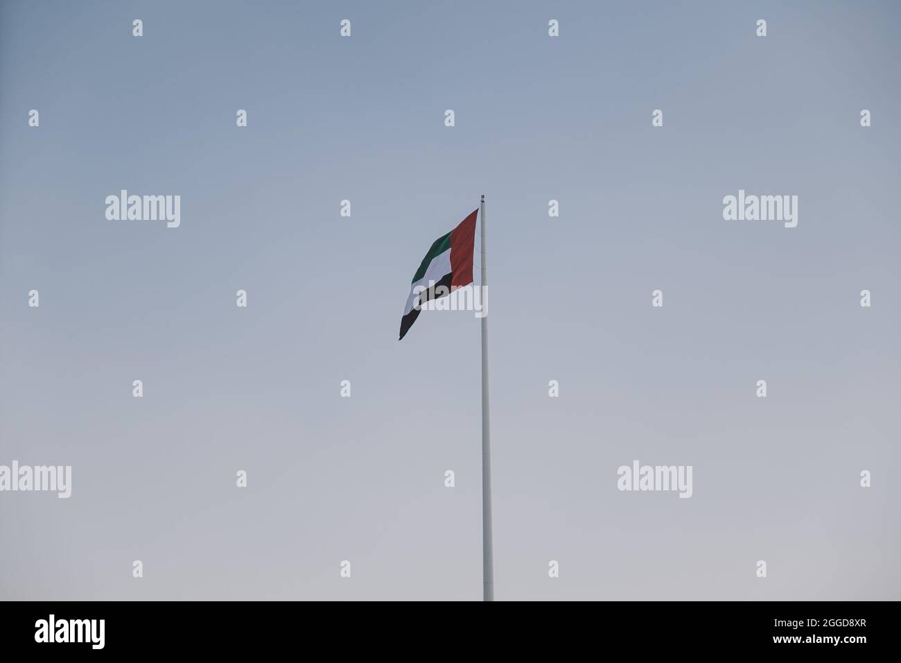 National UAE Waving Flag with Blue Sky View Stock Photo