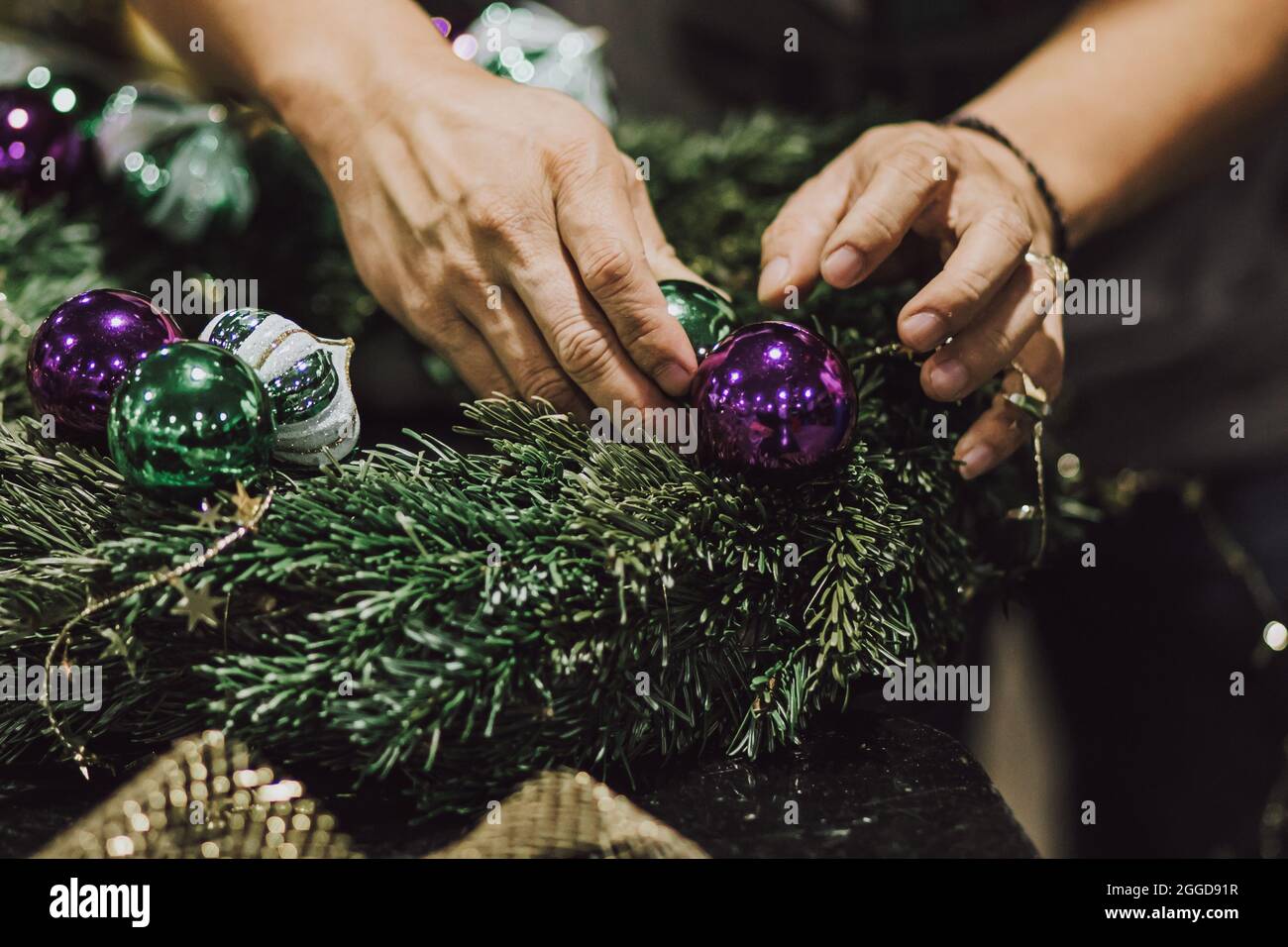 People Making Christmas Wreath with Christmas Decorations Stock Photo
