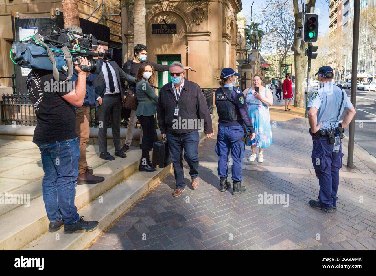 Sydney, Australia. 31 Aug 2021. Mark Latham, the leader of the 'One Nation' political party in NSW, Australia, discretely slips unnoticed past a media throng filming a woman's arrest on Macquarie Street at NSW Parliament House. The woman's arrest came about when she attended a demonstration announced by truck drivers frustrated by COVID-19 lockdown restrictions. Despite claims that they intended to blockade the NSW Parliament building, no trucks or drivers arrived. Credit: Robert Wallace / Wallace Media Network / Alamy Live News Stock Photo