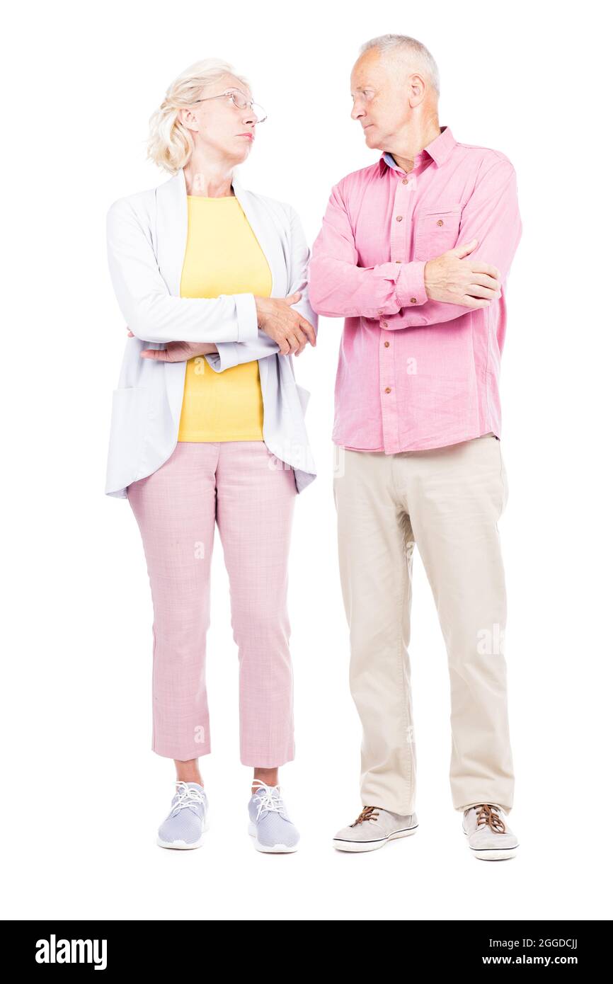 Vertical full length shot of of senior married man and woman standing together looking at each other Stock Photo