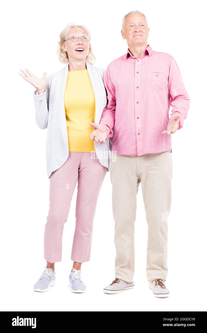 Vertical full length shot of senior Caucasian man and woman wearing casual clothes feeling surprised with good news Stock Photo