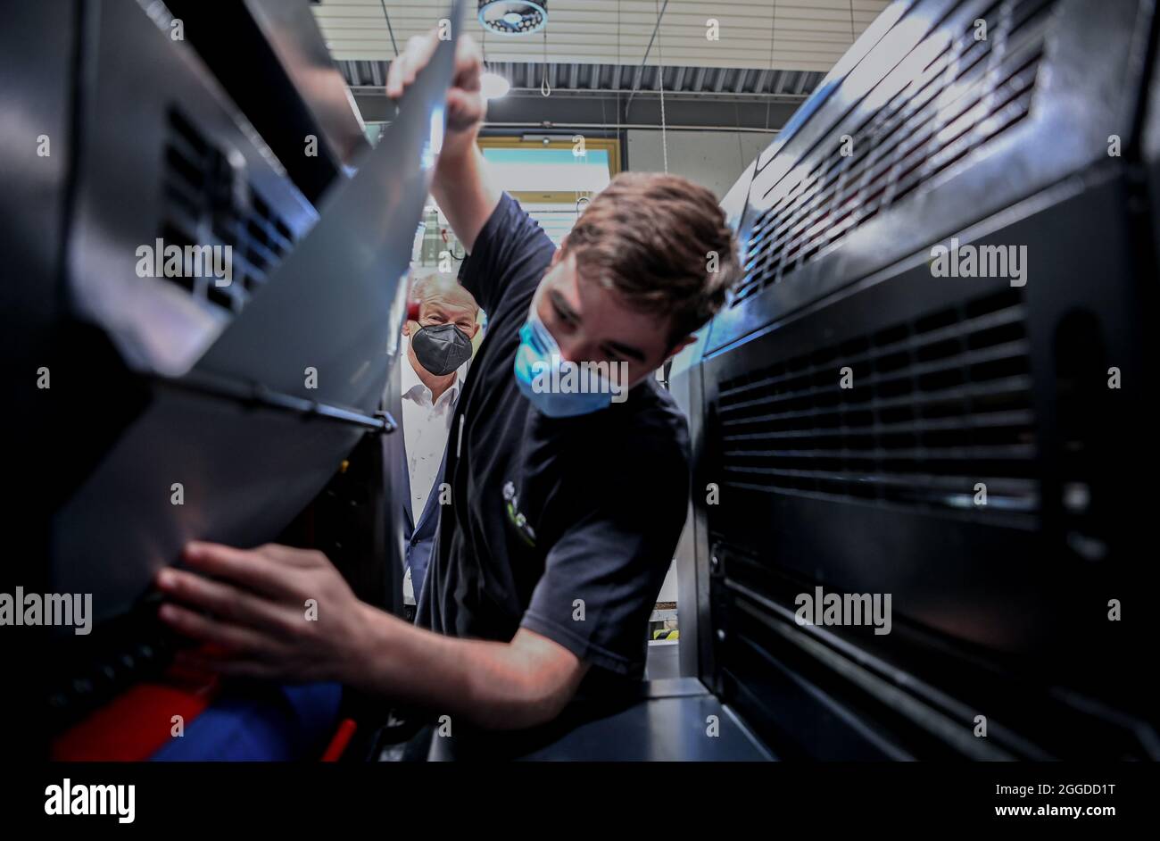 Potsdam, Germany. 31st Aug, 2021. Olaf Scholz (SPD), candidate for the German chancellorship, looks over the shoulder of apprentice Roman Kayser in the workshop of the Oberlin vocational school. Credit: Britta Pedersen/dpa-Zentralbild/dpa/Alamy Live News Stock Photo