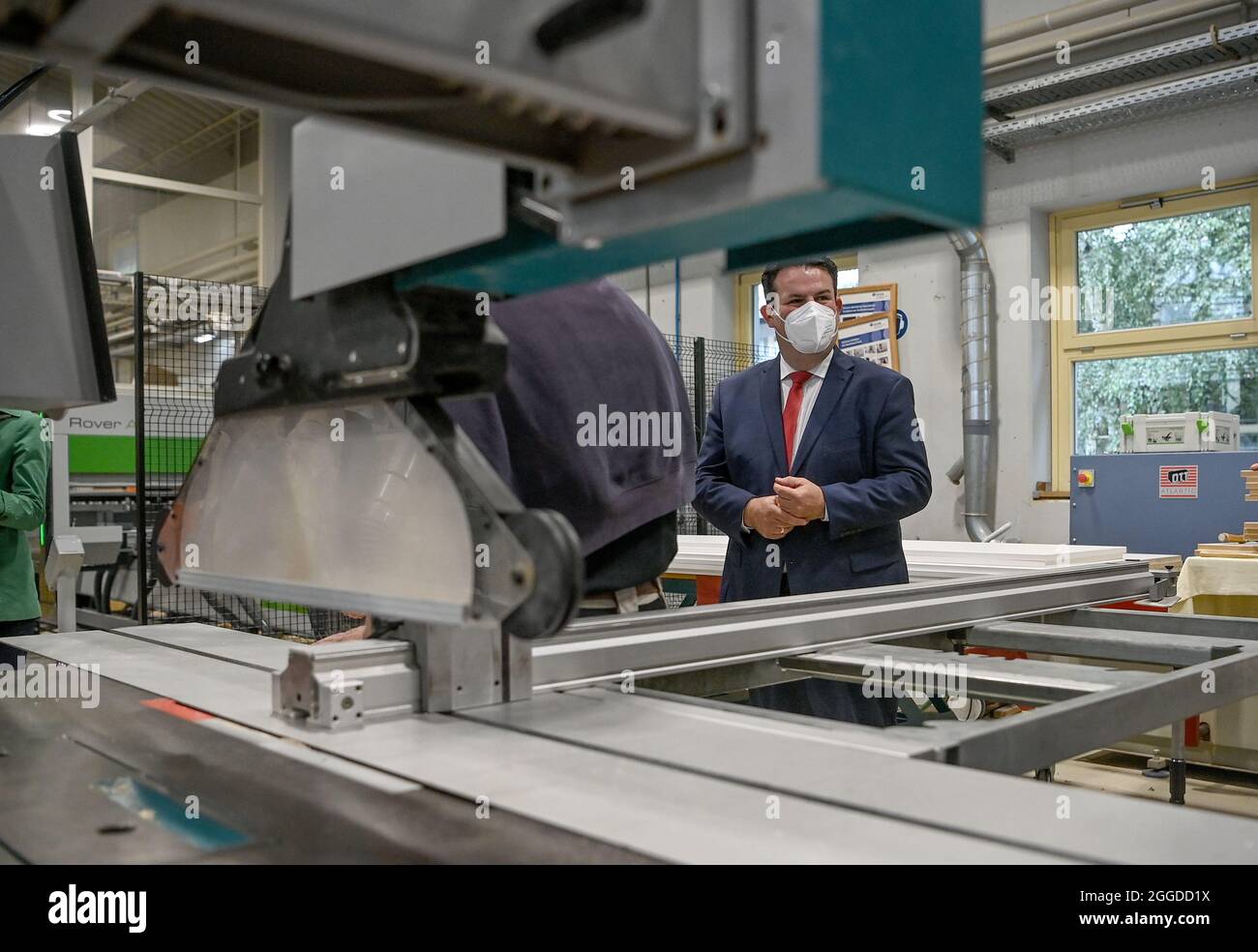 Potsdam, Germany. 31st Aug, 2021. Hubertus Heil (SPD), Federal Minister of Labour and Social Affairs, looks at a machine in the workshop of the training centre Oberlin Berufliche Schulen. Credit: Britta Pedersen/dpa-Zentralbild/dpa/Alamy Live News Stock Photo