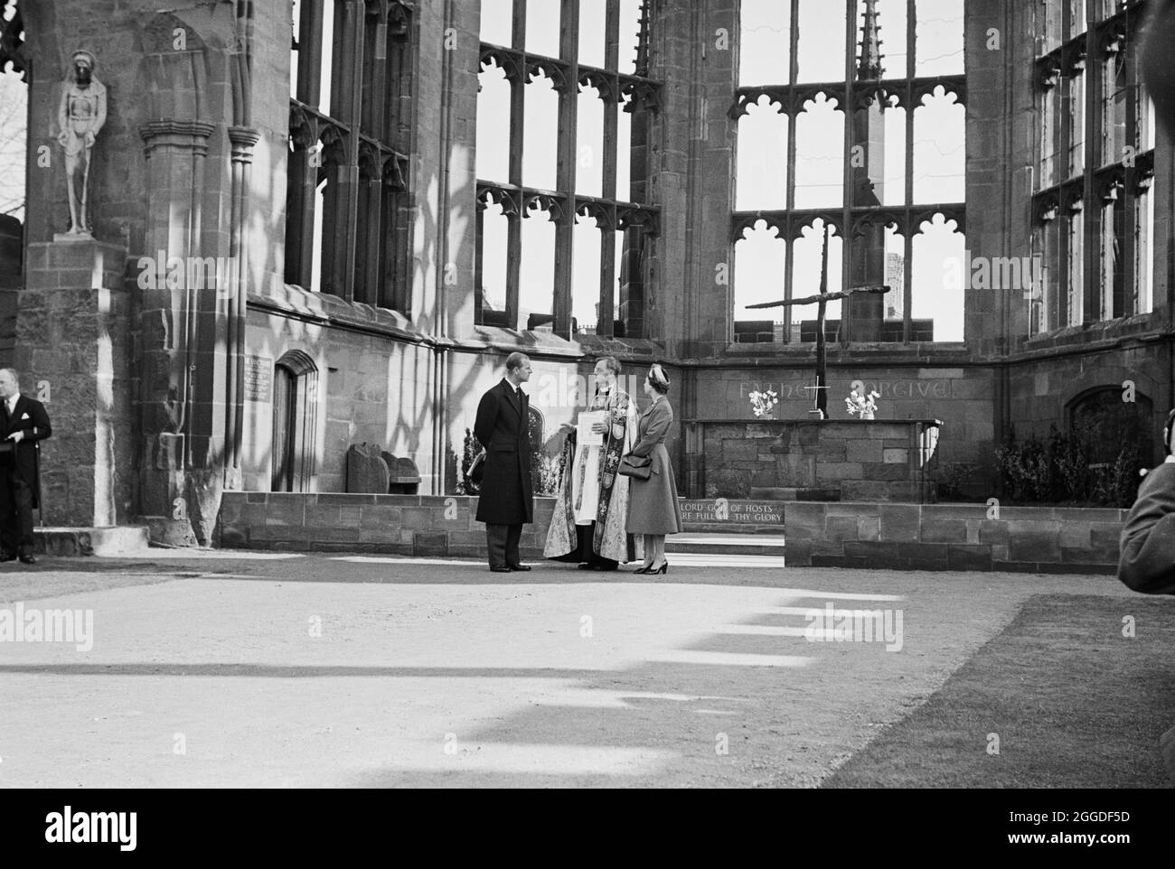 A view of Her Majesty the Queen and the Duke of Edinburgh standing in the ruins of the old cathedral with Provost Howard, on the day of the foundation stone laying ceremony for the new Coventry Cathedral. This image was catalogued as part of the Breaking New Ground Project in partnership with the John Laing Charitable Trust in 2019-20. Stock Photo
