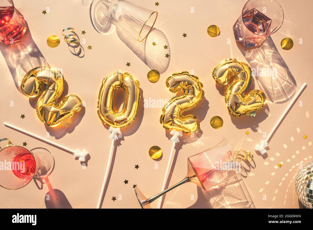 Gold balloons 2022, champagne glasses, confetti Concept of fun party, New Years celebration. After party. Stock Photo