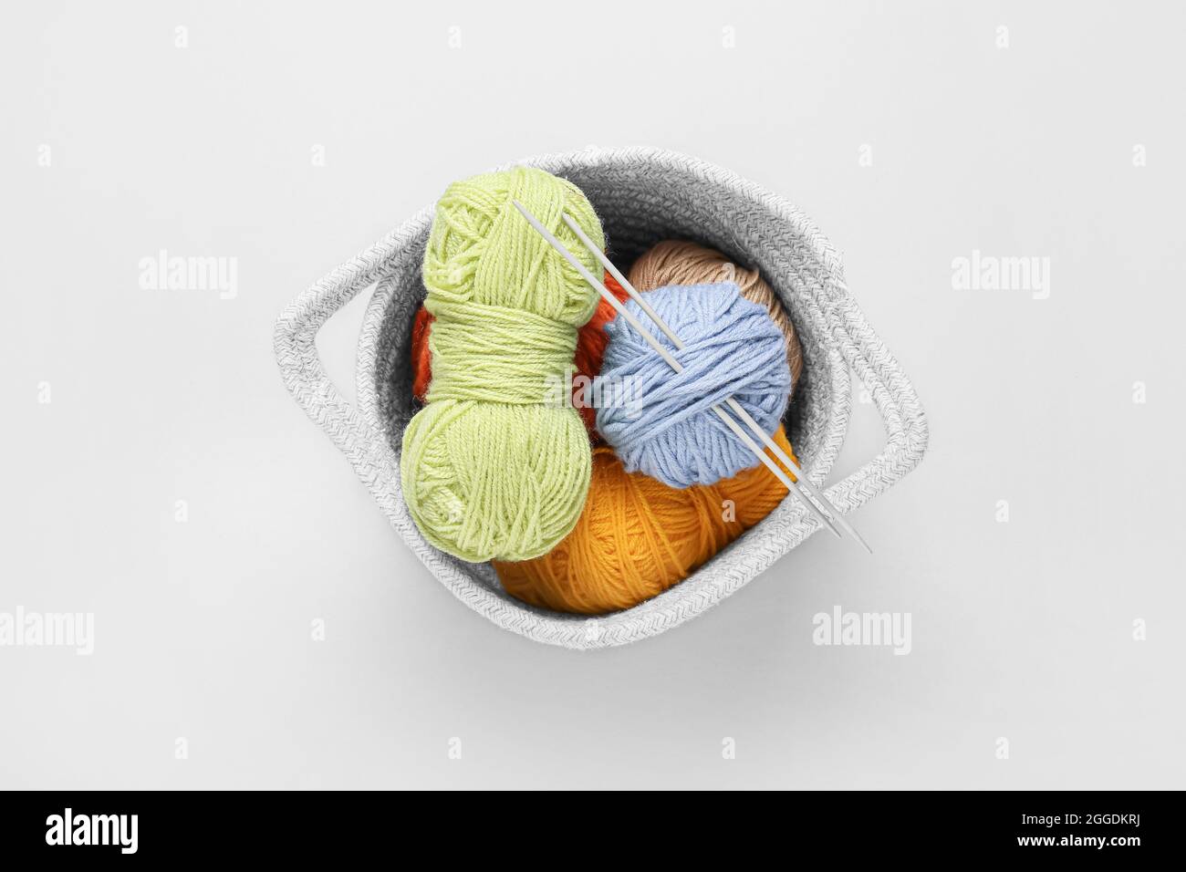 Basket with knitting yarn and needles on white background Stock Photo ...