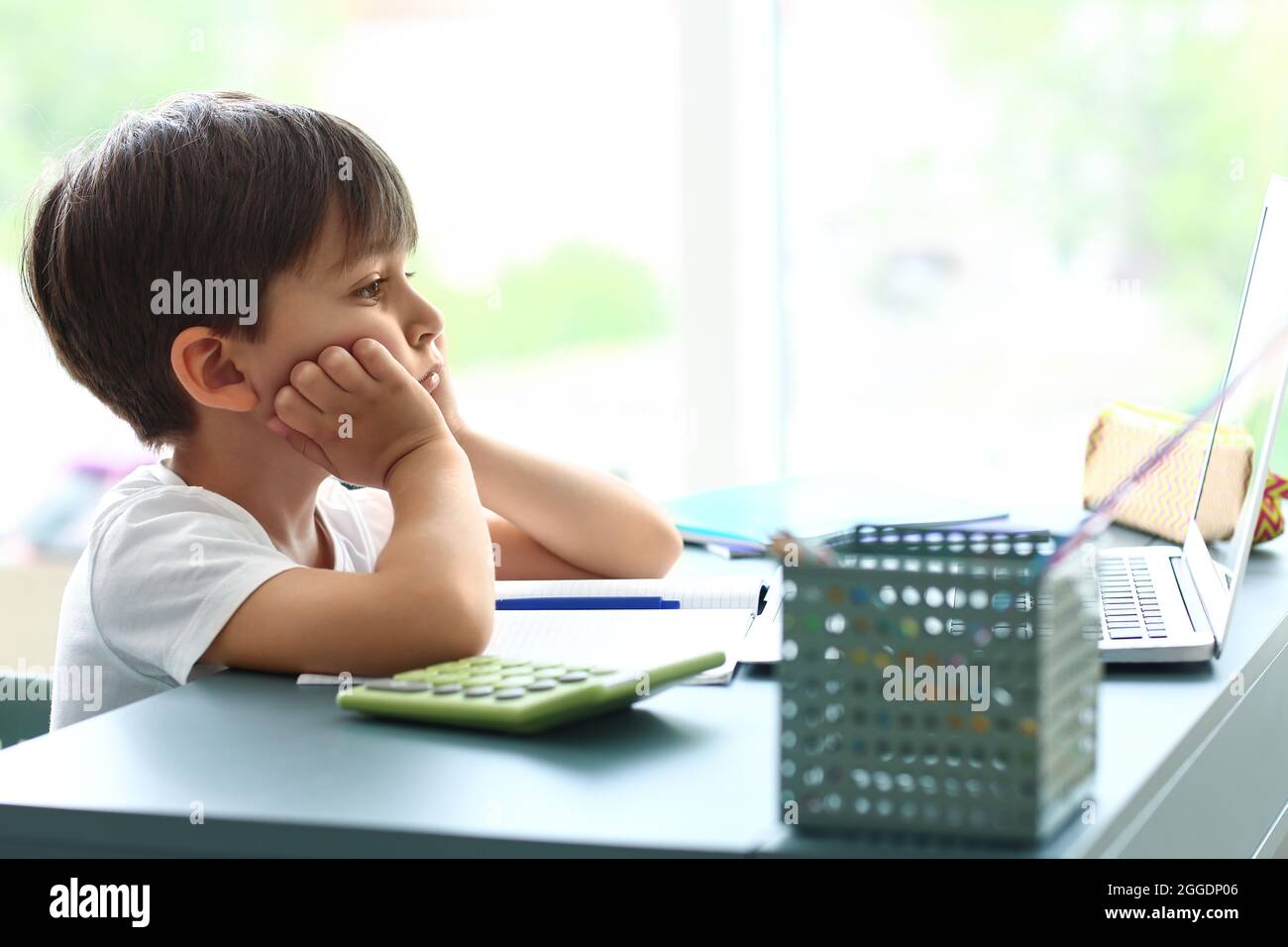 Little boy tired of studying online at home Stock Photo