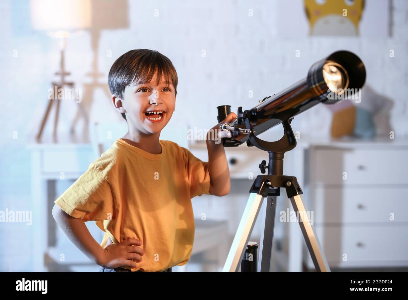 Little boy with telescope looking at stars in evening Stock Photo