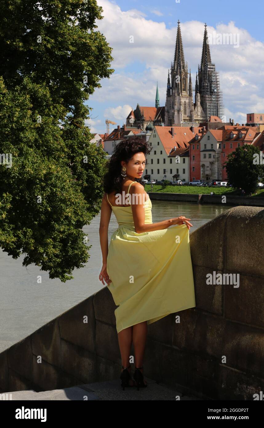 Regensburg Altstadt oder Innenstadt oder City mit schwarzhaariger Schönheit mit sinnlichen Blick und  gelben Kleid. Oberpfalz, Bayern, Regensburg. Stock Photo