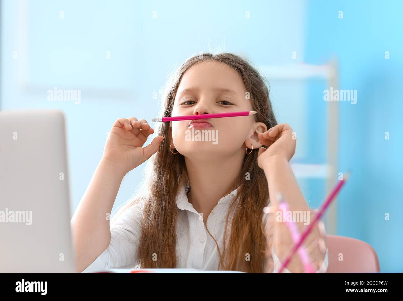 Little girl with pencil at home Stock Photo