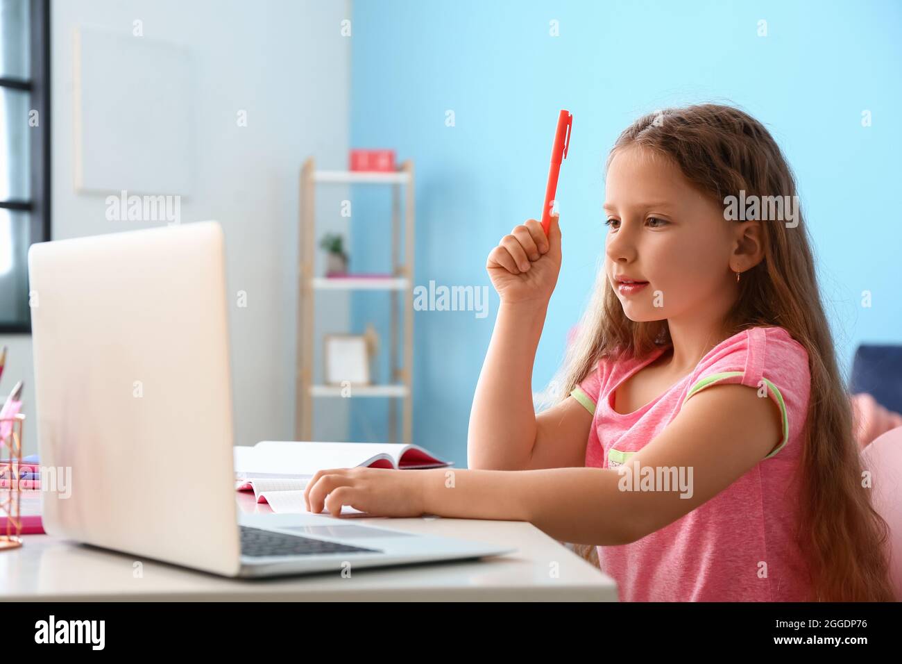 Little girl studying online at home Stock Photo