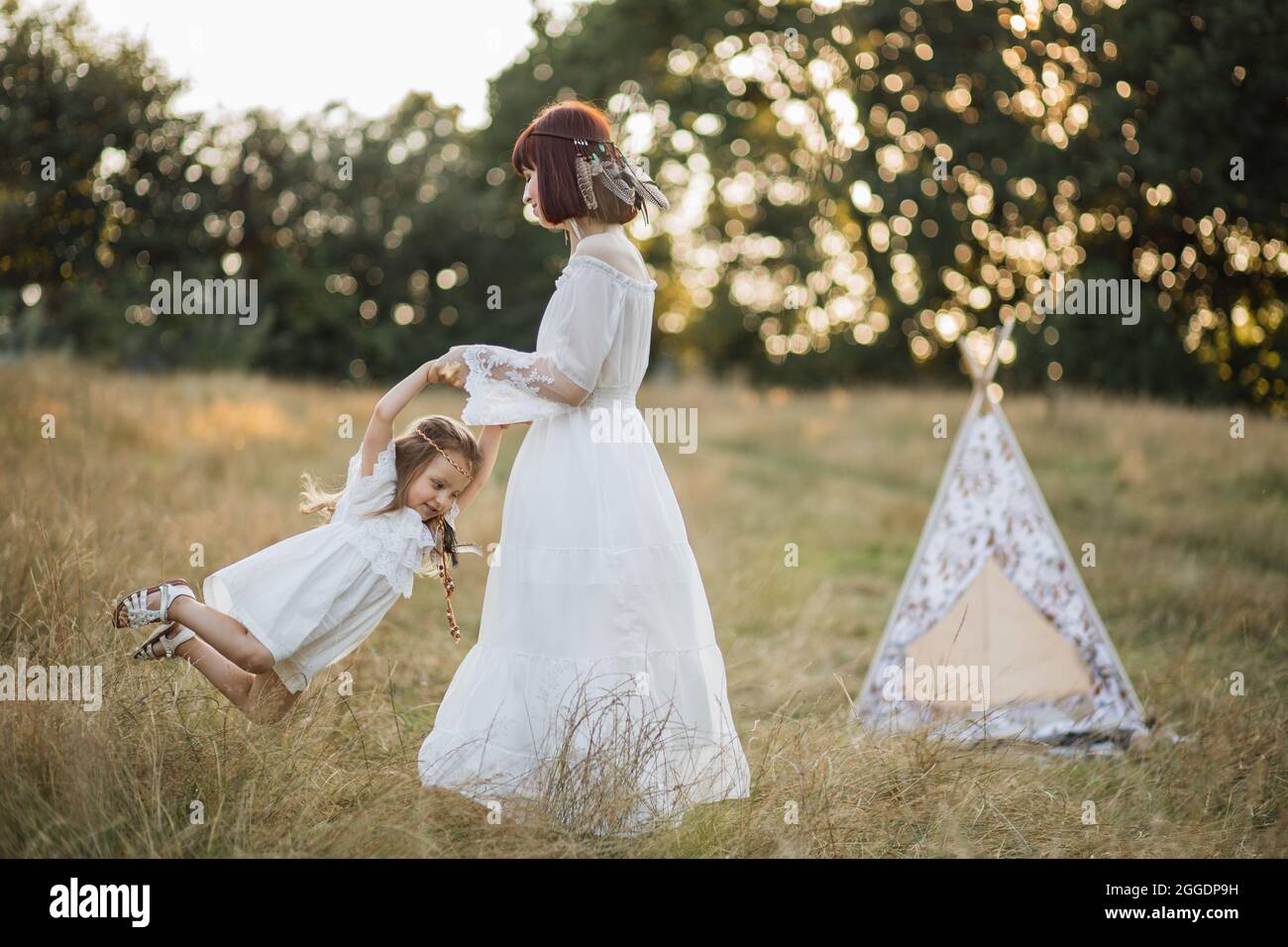 Family, mother's day, emotions concept. Mother and daughter dressed in  native american style, having fun in