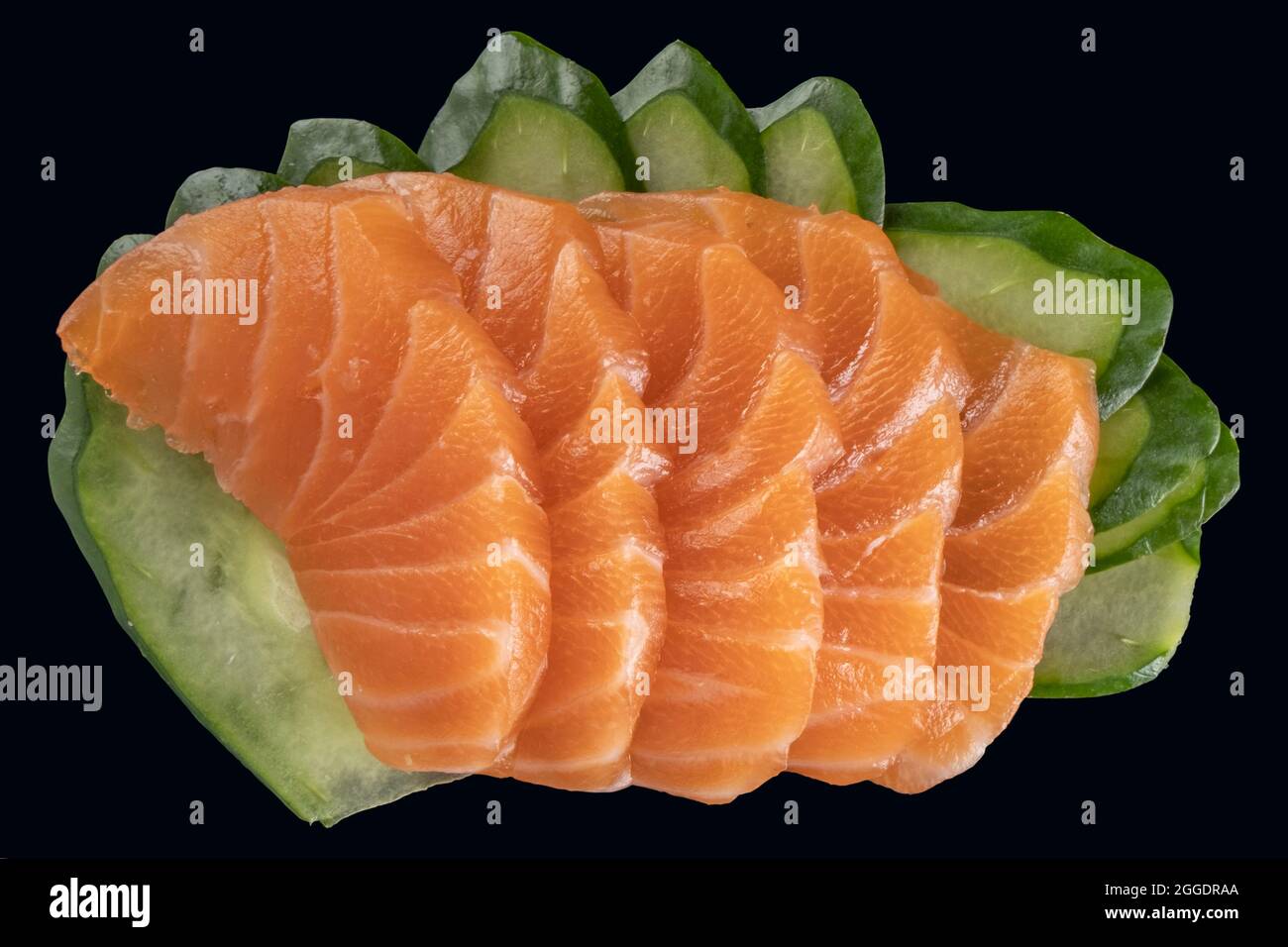salmon sashimi and slices of cucumber on black background Stock Photo