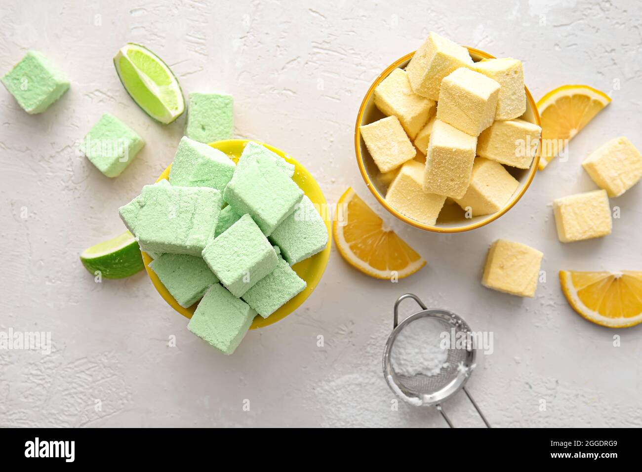Bowls with tasty sweet marshmallows and orange on light background ...