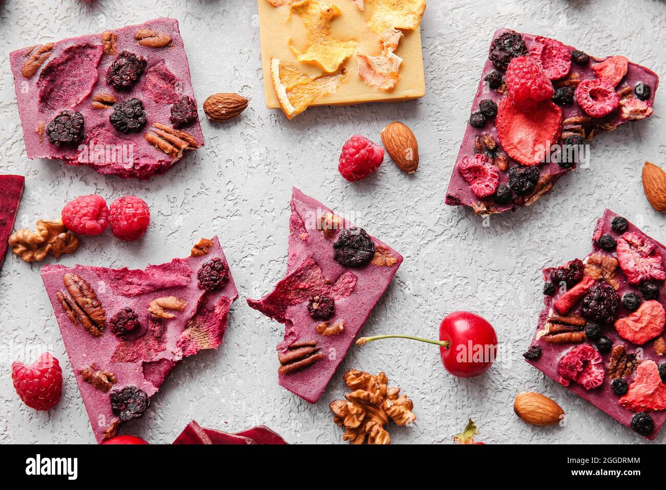 Handmade chocolate bars with fruits, berries and nuts on grey ...
