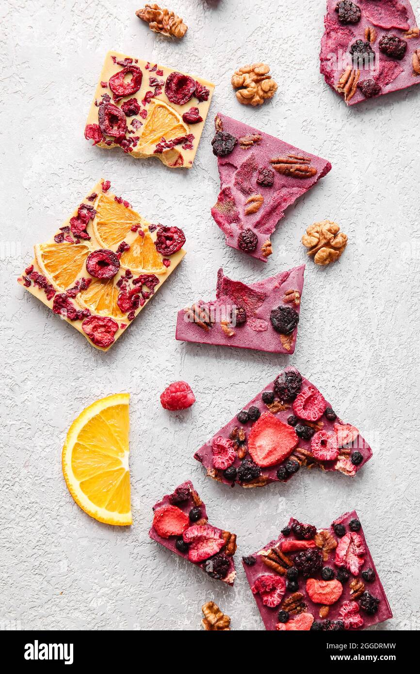 Handmade chocolate bars with fruits, berries and nuts on light ...