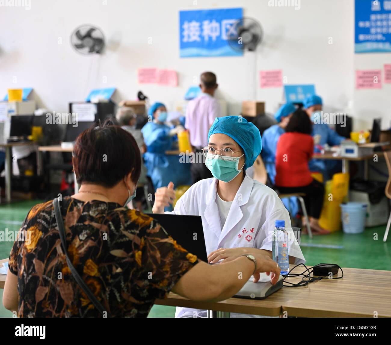 Jinjiang, China's Fujian Province. 31st Aug, 2021. A medical worker registers information of an old woman who comes to receive a COVID-19 vaccine in Neikeng Town in Jinjiang City, southeast China's Fujian Province, Aug. 31, 2021. To solve the 'last mile' problem of COVID-19 vaccination in rural areas, the government of Jinjiang City has recently set up in-village vaccination sites and provided free shuttle buses, making vaccination services more convenient for local villagers especially elderly people. Credit: Song Weiwei/Xinhua/Alamy Live News Stock Photo