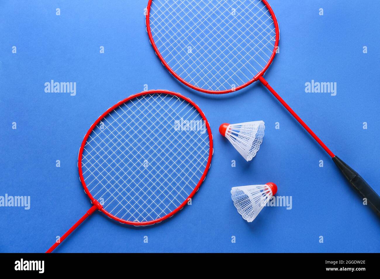 Badminton rackets and shuttlecocks on color background Stock Photo
