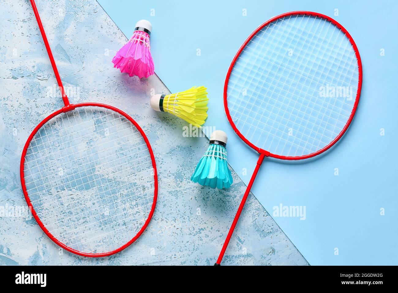 Badminton rackets and shuttlecocks on color background Stock Photo