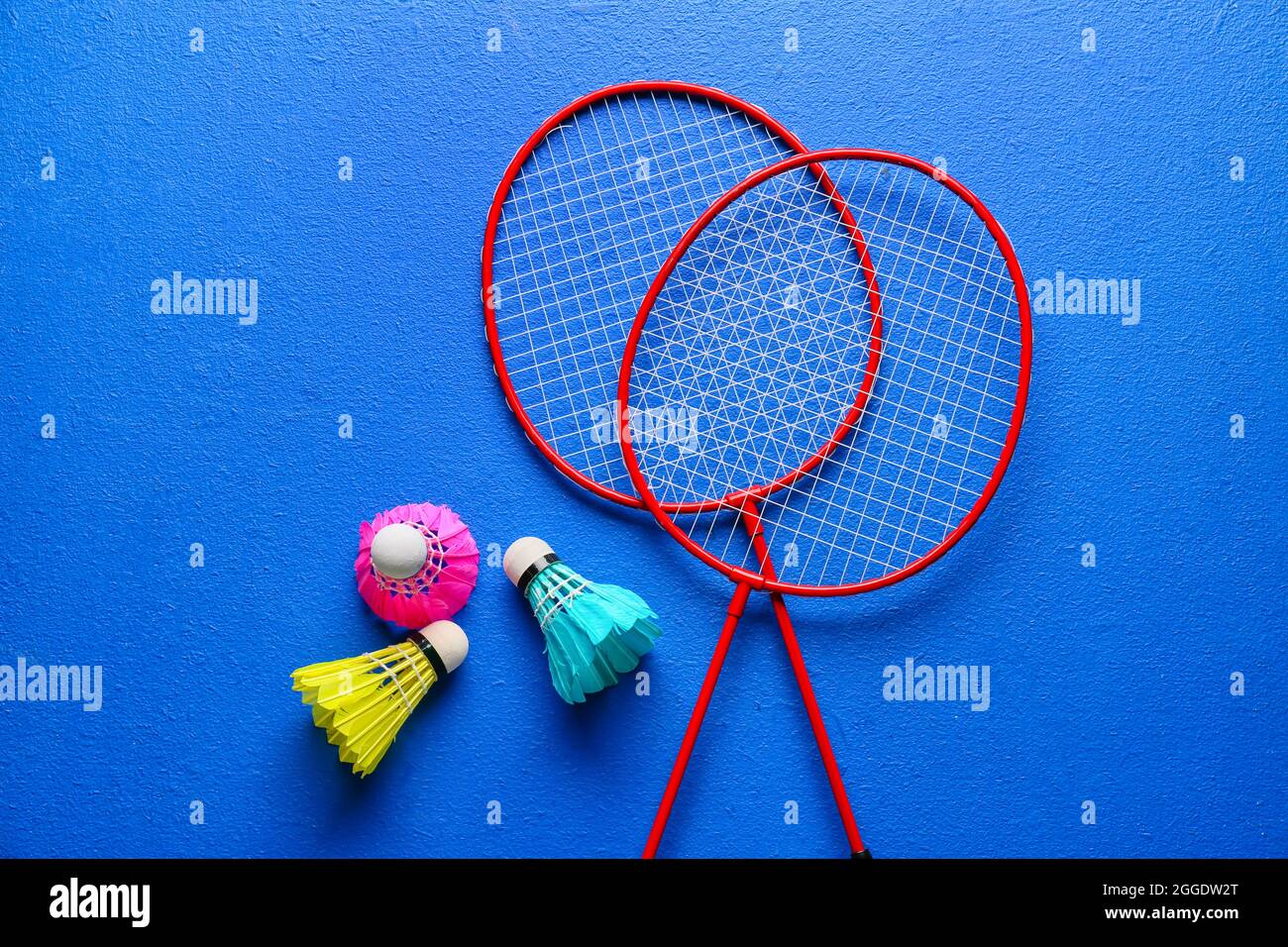 Badminton rackets and shuttlecocks on color background Stock Photo