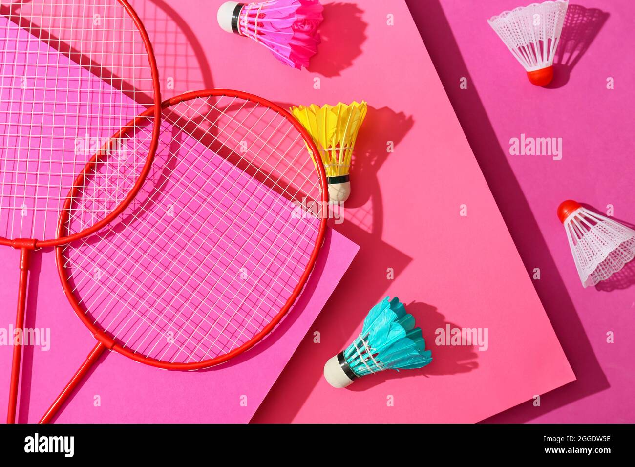 Badminton rackets and shuttlecocks on color background Stock Photo
